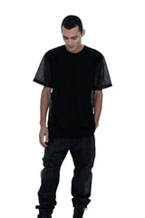 Person wearing a black outfit with a t-shirt, pants, and boots on a white background