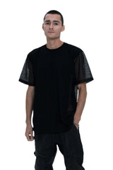 Person wearing a black outfit with a t-shirt, pants, and boots on a white background