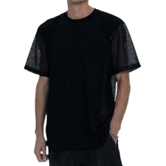 Person wearing a black outfit with a t-shirt, pants, and boots on a white background